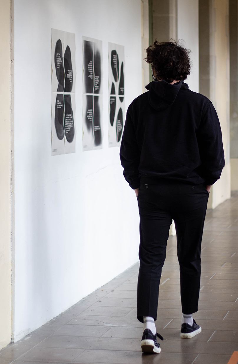 Photographie du projet affiché sur les murs d'une école, avec le passage d'un étudiant
